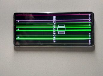 「スマートフォンの画面に表示される無数の色とりどりの線で、画面トラブルを示している写真。」