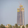 「サウジアラビア、リヤドにあるジッダ・タワーの建設現場。周囲はパームツリーに囲まれた住宅地が広がっている。完成すれば、このタワーは世界で最も高い建築物になることが期待されている。」
