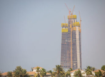 「サウジアラビア、リヤドにあるジッダ・タワーの建設現場。周囲はパームツリーに囲まれた住宅地が広がっている。完成すれば、このタワーは世界で最も高い建築物になることが期待されている。」